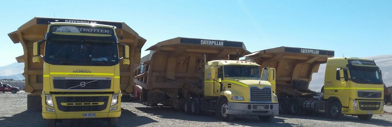 Three Logística Inversol trucks carrying mining truck dump bodies on lowboy trailers