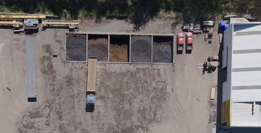Aerial view of the material stockpiles in Logística Inversol's yard, with a truck positioned for loading