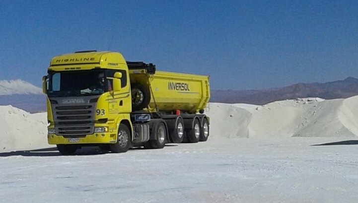 Loaded Logística Inversol truck on a salt flat in the Bolivian altiplano, with the Andes in the background