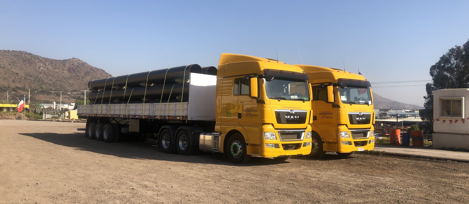 Two Logística Inversol MAN trucks, one with an extended semi-trailer loaded with large-diameter pipes
